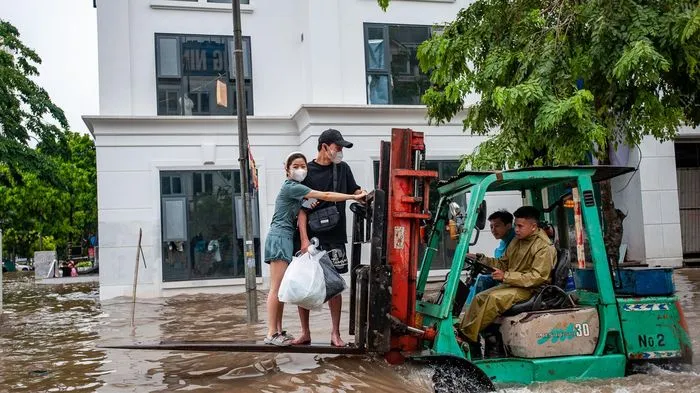 Người dân Thủ đô ‘cưỡi’ xe nâng vượt biển nước đi làm sau bão số 2